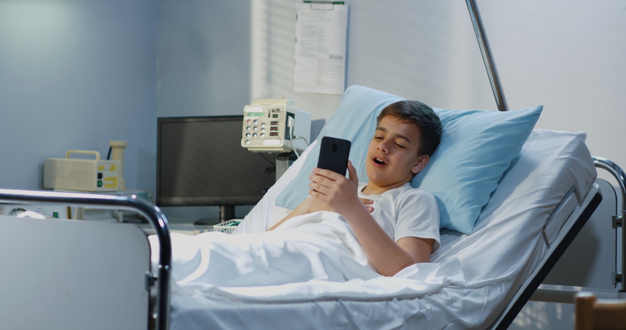 Teenager patient using cell phone in hospital